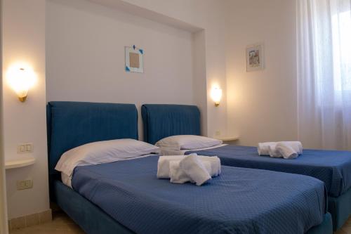 two blue beds in a room with towels on them at BouganVilla in Polignano a Mare