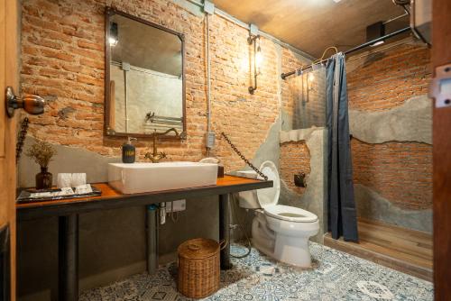 a bathroom with a sink and a toilet at House of Machine Boutique Hotel in Bangkok