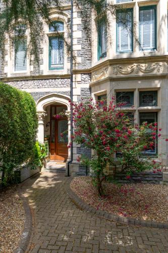 a house with a brick walkway in front of a building at Prime Location Cardiff Pontcanna Modern 2 Bedroom Apartment with Privat Parking in Cardiff
