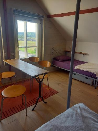 une pièce avec une table, des chaises et un lit dans l'établissement VELOFT, à Villebernier