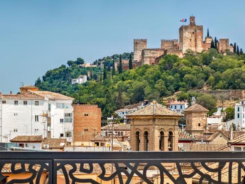 a view of a city with a castle on a hill at Palacio Gran Vía, a Royal Hideaway Hotel in Granada