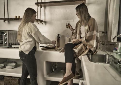 dos mujeres de pie en una cocina preparando comida en Cinco Cumbres en Uspallata