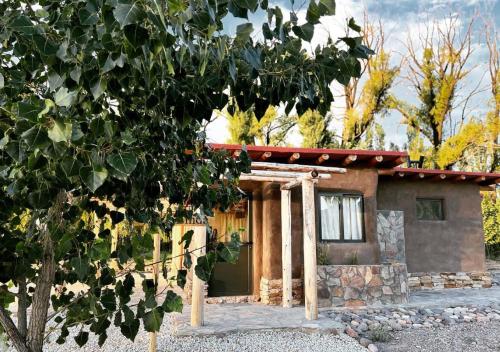 a small house with a tree in front of it at Cinco Cumbres in Uspallata