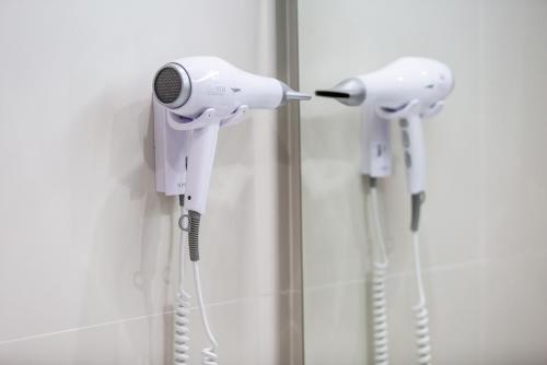 a pair of hair dryers hanging on a wall at Hotel Monte Puertatierra in Cádiz