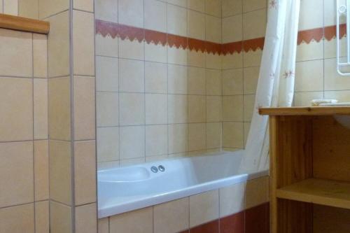 La salle de bains carrelée est pourvue d'une baignoire et d'une douche. dans l'établissement Venus - 2 bedroom apartment next to the slopes, à Sainte-Foy-Tarentaise