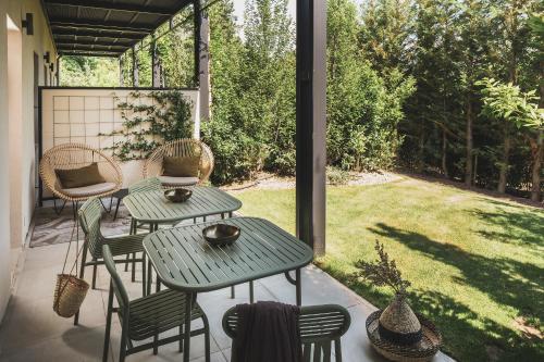 a patio with two tables and chairs and a yard at Les Lodges Sainte-Victoire Hotel & Spa in Aix-en-Provence