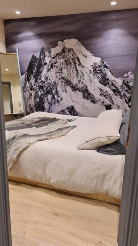 a bed with a mountain mural on the wall at Cocooning in Arvier