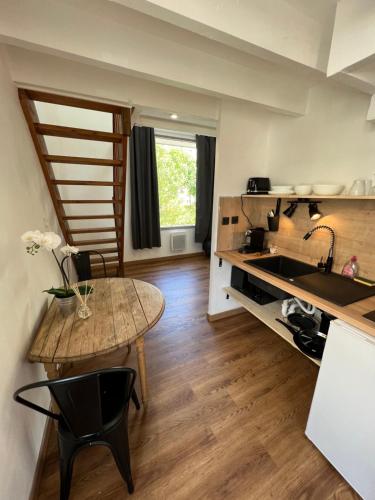 une petite cuisine avec une table et un évier dans l'établissement TRÈS CHARMANT DUPLEX ROTONDE*WIFI*CLIM*SMART TV, à Aix-en-Provence