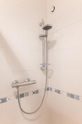 une douche dans une salle de bain avec une pomme de douche dans l'établissement Appartement privé Le Chardonnay, jardin, parking, à Buchères