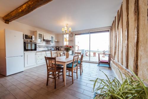 a kitchen and dining room with a table and chairs at Appartement privé Le Chardonnay, jardin, parking in Buchères