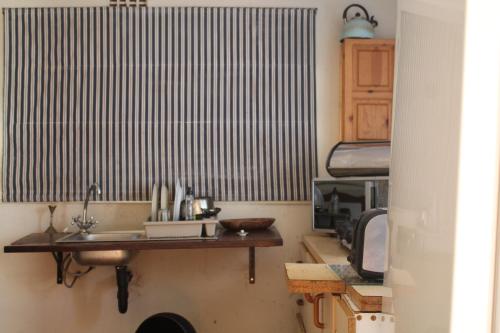 a kitchen with a sink in a room with a bed at Isikhoma-Khoma in Hilton