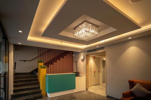 a lobby with a ceiling with a chandelier and stairs at Sparrow Hotel Managed by Siara Sariska Alwar in Alwar