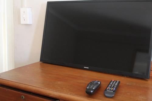 two remote controls sitting next to a television on a dresser at Isikhoma-Khoma in Hilton