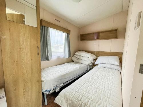 a small room with two beds and a window at Lovely 8 Berth Caravan With Decking At Eastgate Fantasy Island Park Ref 58004c in Skegness
