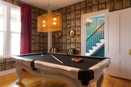 a billiard table in a room with a staircase at Gilded in Newport