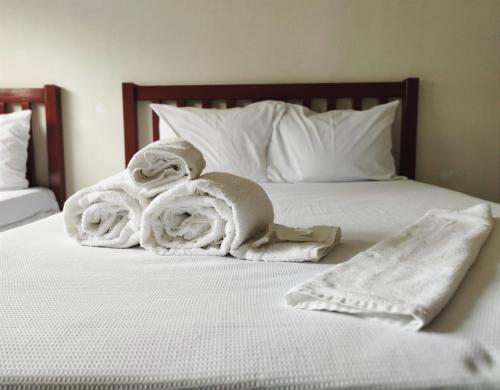 Una cama con toallas blancas encima. en Novohotel Express, en Santana do Livramento
