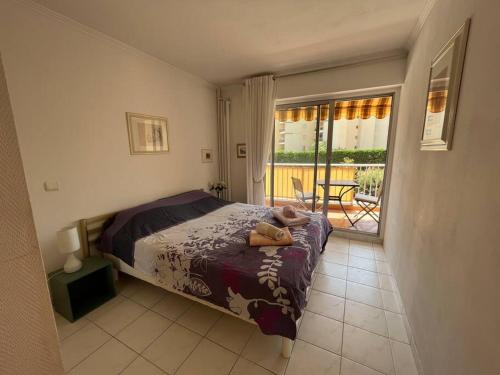 een slaapkamer met een bed en een balkon bij 2 Pièces Piscine Parking Clim - Le Fairway in Mandelieu-la-Napoule