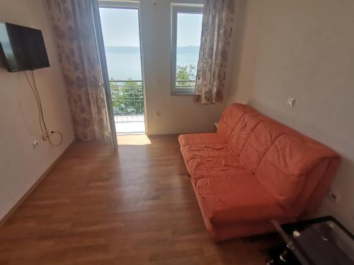 ein Wohnzimmer mit einem Sofa und einem großen Fenster in der Unterkunft Guesthouse Zimovski in Peštani