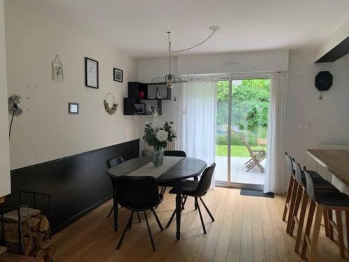 une cuisine et une salle à manger avec une table et des chaises dans l'établissement Charmante Maison avec jardin proche Rennes, à Saint-Grégoire
