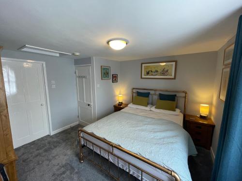 a bedroom with a bed and two lamps and a door at Ivy Cottage, in Lostwithiel