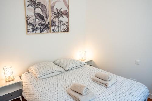 um quarto com uma cama branca e toalhas em La Mésange Huppée #8 Gare em Quimper