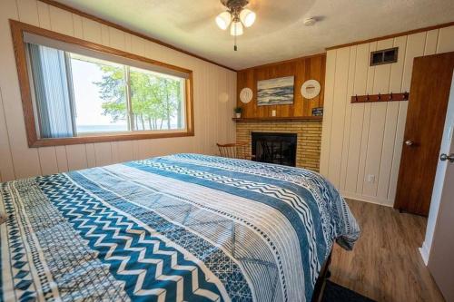 a bedroom with a large bed and a fireplace at Beautiful home on Lake Michigan, near Escanaba 