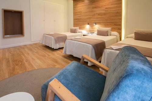 a hotel room with three beds and a couch at Hotel Monte Puertatierra in Cádiz