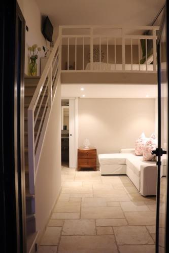 a living room with a white couch and stairs at L'antico Trullo - Masseria Chiancarella in Fasano
