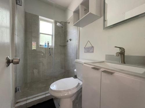 uma casa de banho com um chuveiro, um WC e um lavatório. em Casa Habana Studios em Miami