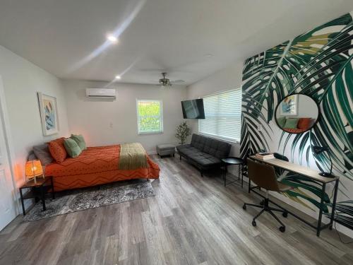 a bedroom with a bed and a couch and a desk at Casa Habana Studios in Miami