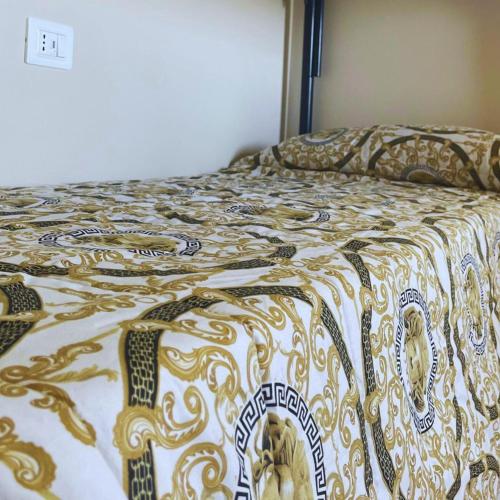 una cama con un edredón encima en NuMaChi Rooms, en San Nicolò