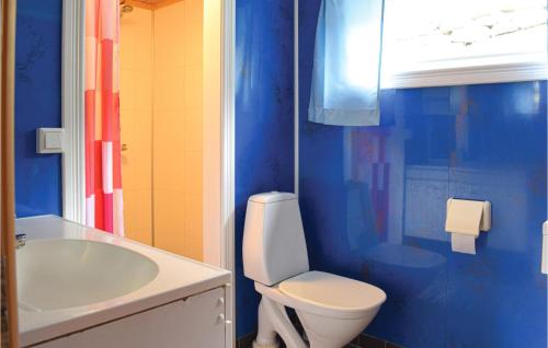 uma casa de banho azul com um WC e um lavatório em 4 Bedroom Awesome Home In Heidal em Heidal