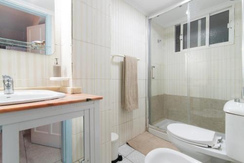 Un baño con inodoro, lavabo y ducha. en Las Canteras Verol with Garage, en Las Palmas de Gran Canaria