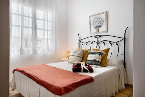 a bedroom with a large bed with gold pillows at Casa Cordel in Playa Honda