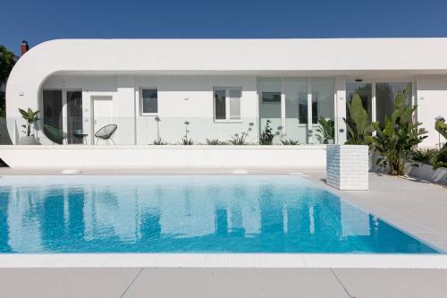 a villa with a swimming pool in front of a house at Stellaris Apartrooms in Termoli