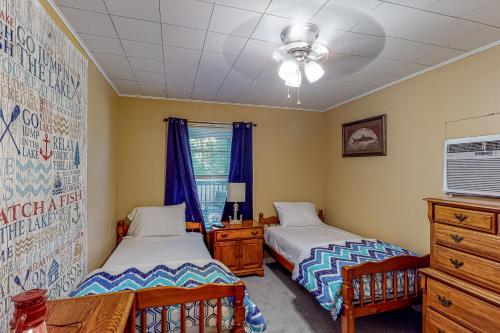 a bedroom with two beds and a table and a window at Keepin' it Reel in Avinger