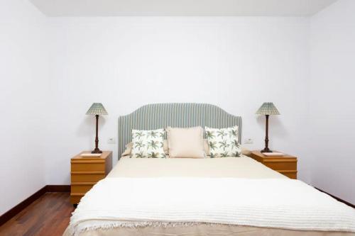 a bedroom with a white bed with two lamps at Casa Carolina in Puntillo del Sol
