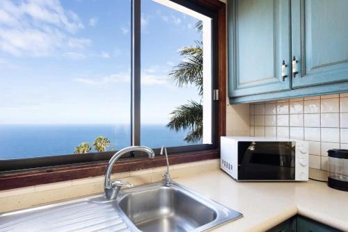 fregadero de cocina y ventana con vistas al océano en Casa Carolina en Puntillo del Sol