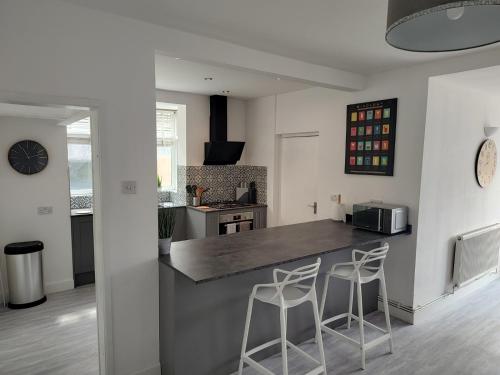 a kitchen with a counter and two stools at Wavertree Drive 3 bed contractor home in Leicester in Leicester