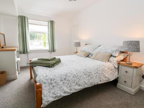 een slaapkamer met een groot bed en een raam bij Bluebell Cottage in Ormskirk