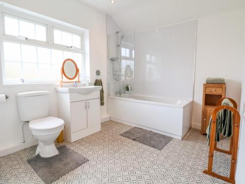 a bathroom with a toilet and a tub and a sink at Bluebell Cottage in Ormskirk