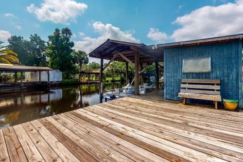a wooden dock with a bench next to a building at Sunshine House in Astor