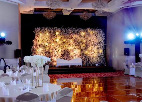 a banquet hall with white tables and chairs and a wall of lights at Kuwait Grand Hotel in Kuwait
