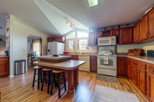 a kitchen with wooden cabinets and a kitchen island with bar stools at Sunshine House in Astor