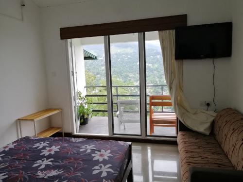 ein Wohnzimmer mit einem Sofa und einem großen Fenster in der Unterkunft Glenview hotel & homestay in Kandy