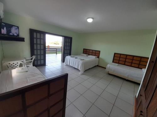um quarto de hotel com duas camas e uma varanda em Paraíso do sul - Carmery em Pontal do Paraná