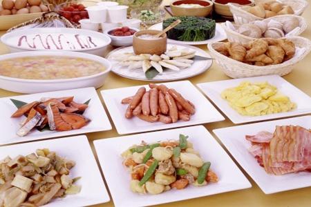 una mesa cubierta con platos de diferentes tipos de alimentos en Hotel Unisite Sendai en Sendai