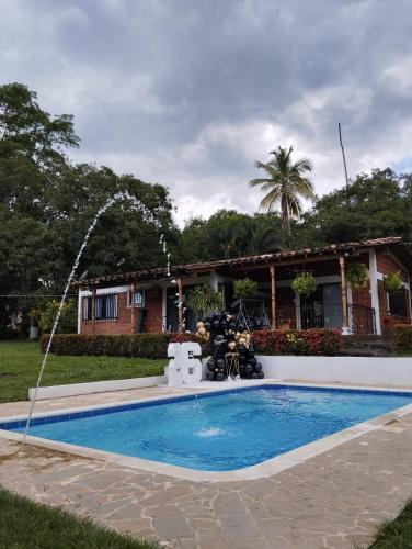 una piscina con una fuente frente a una casa en Finca de Descanso - Sopetrán en Sopetran
