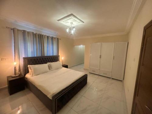 Un dormitorio con una cama grande y una ventana en After 5 Apartment 1- 3 spacious en-suite bedrooms en Freetown