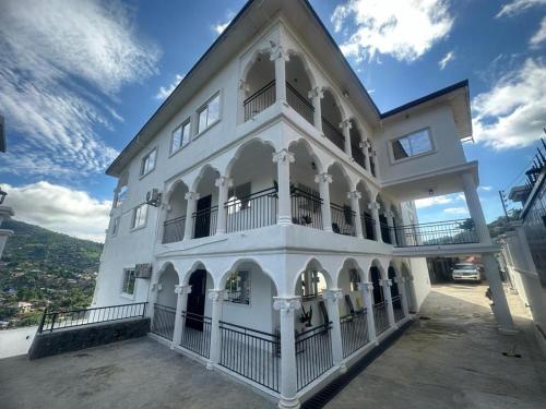 a white building with a balcony and a blue sky at After 5 Apartment 1- 3 spacious en-suite bedrooms in Freetown